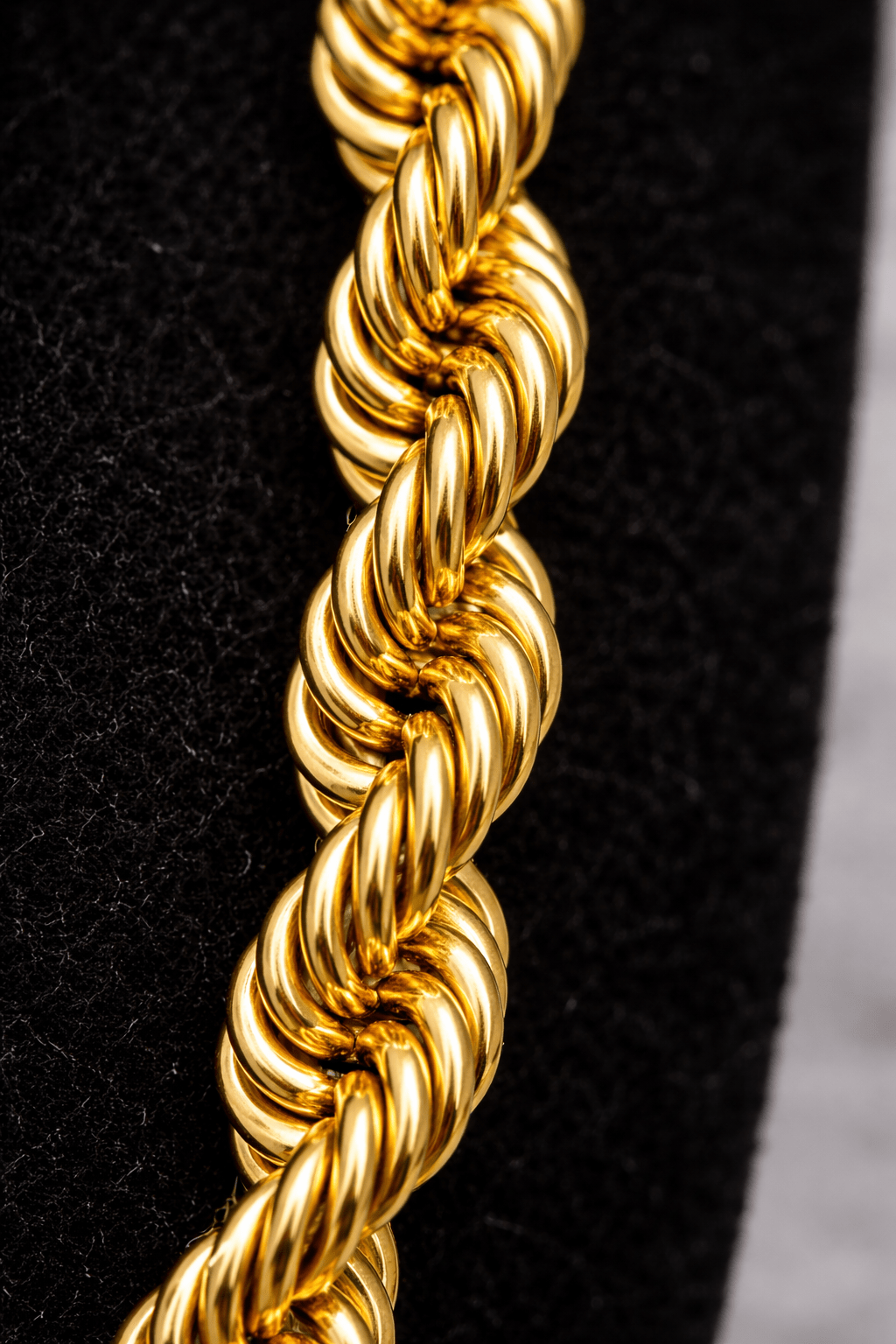 Close-up of a gold rope chain on a black background