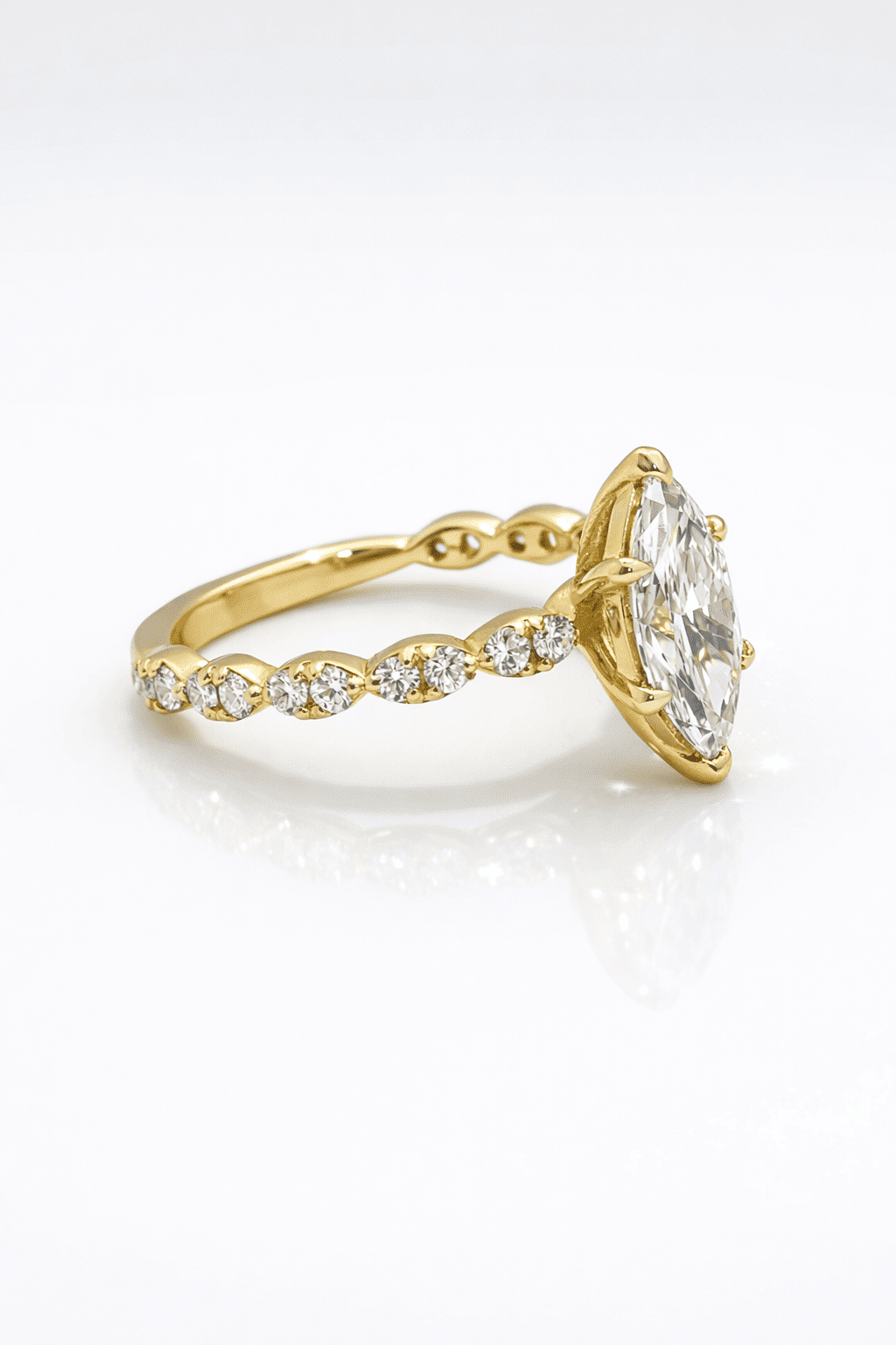 Gold ring with a large diamond and smaller diamonds on the band against a white background