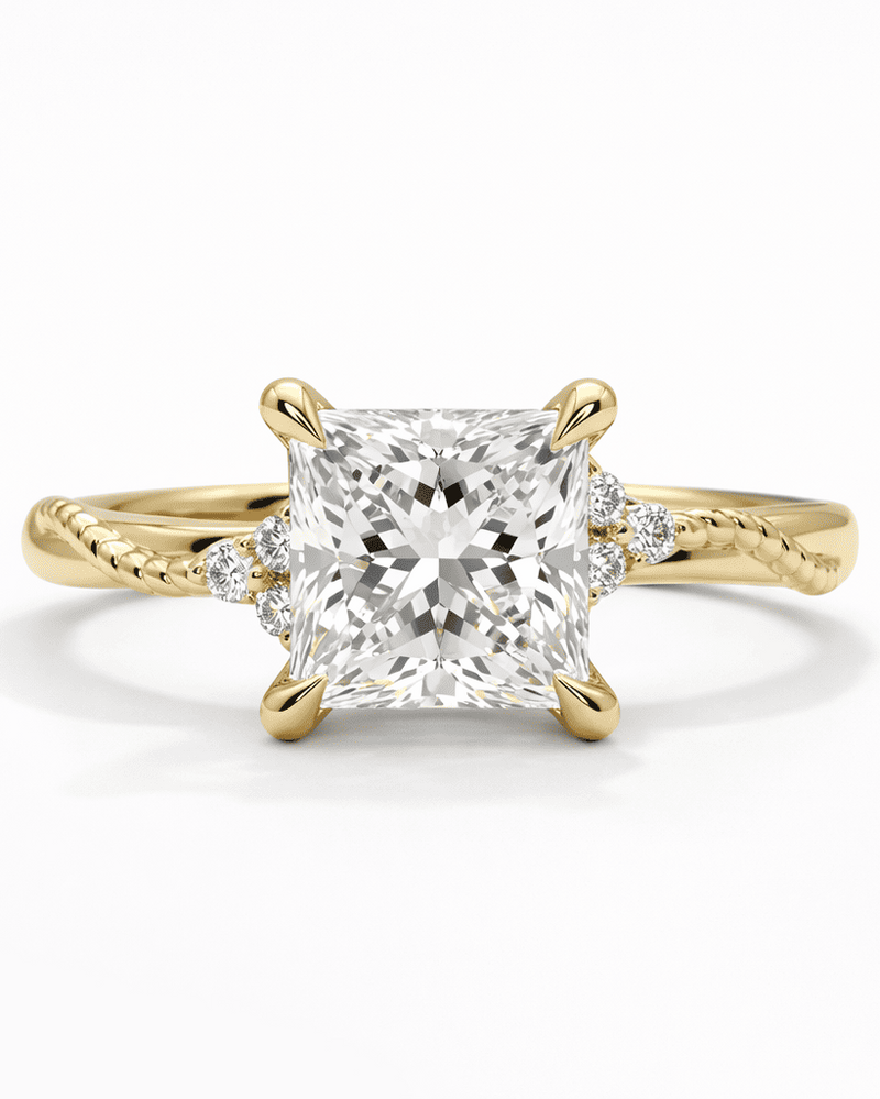 Gold ring with a large diamond and smaller diamonds on the band against a white background