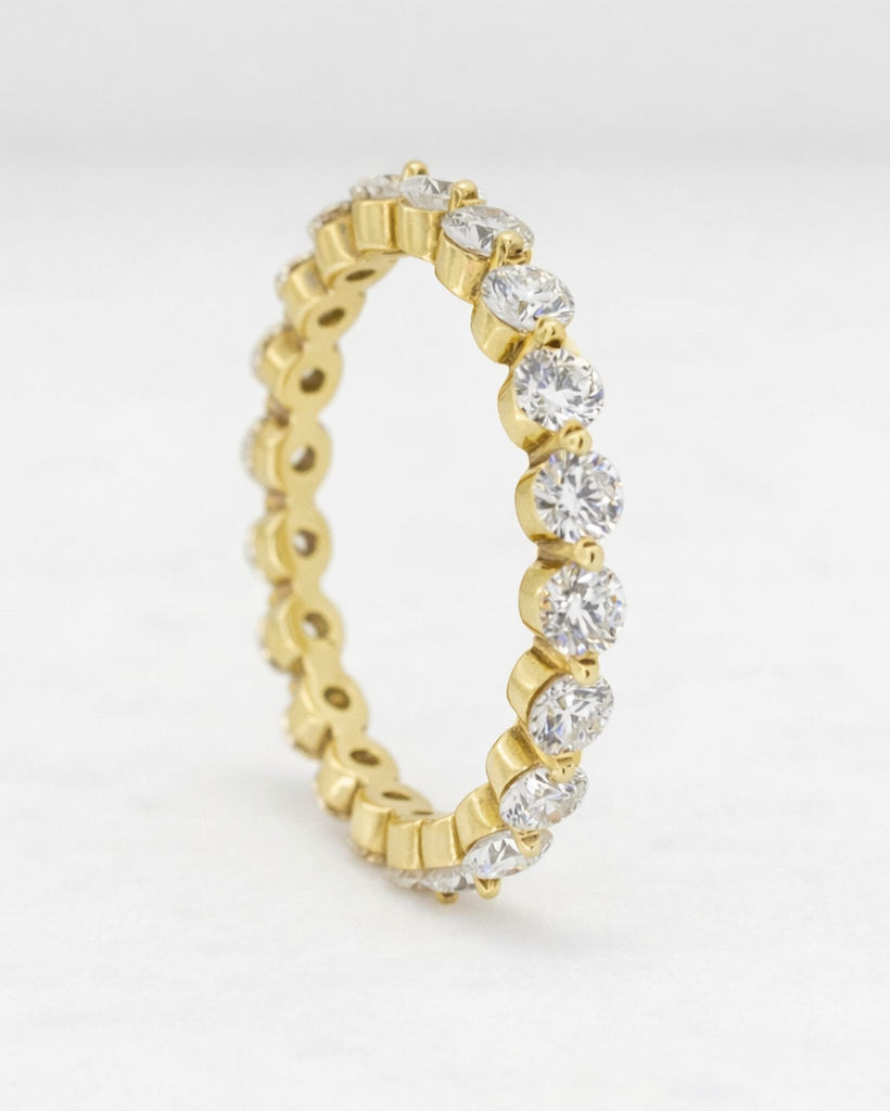 Gold and diamond ring on a light gray background