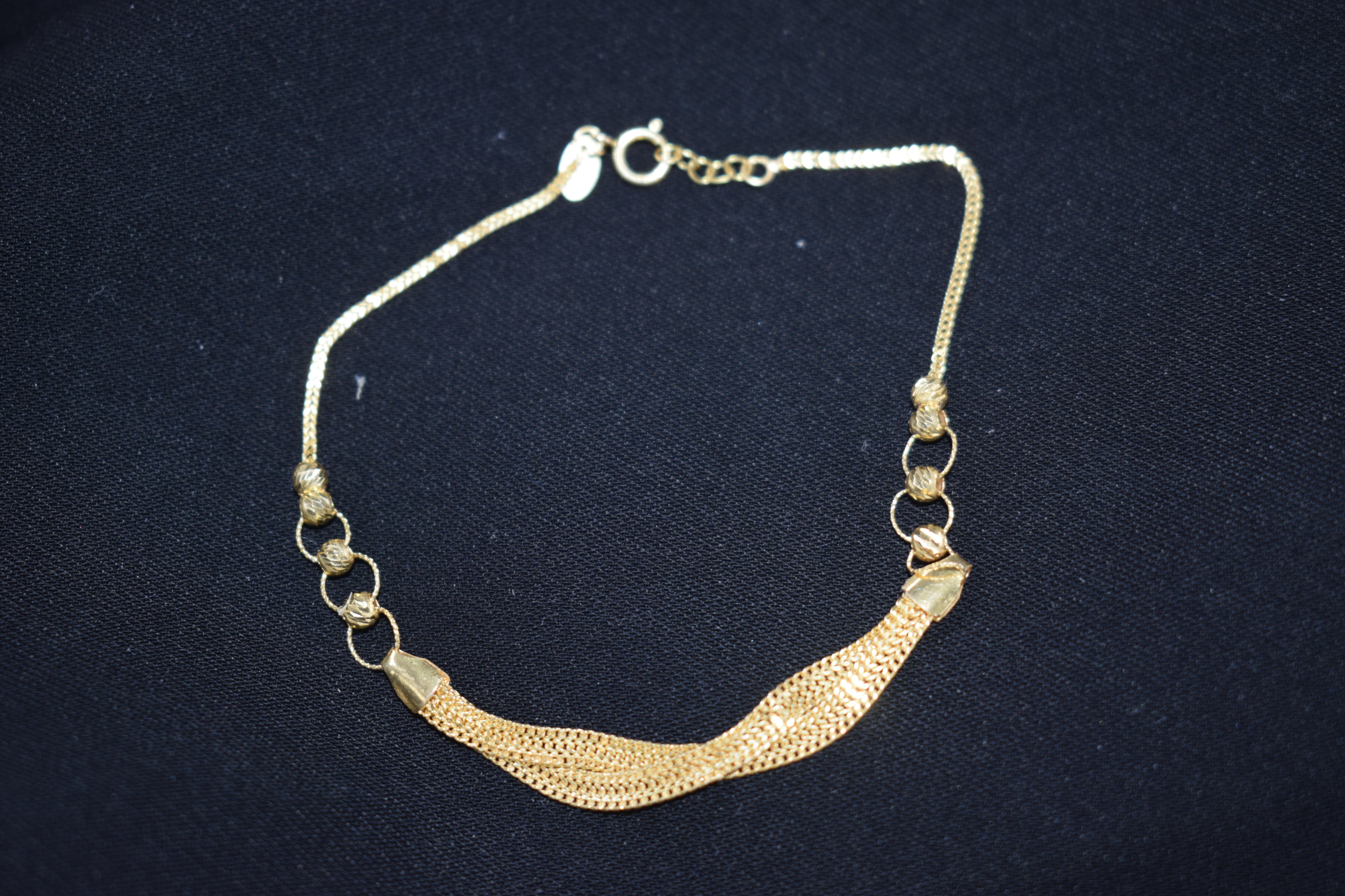 Gold bracelet on a dark blue background