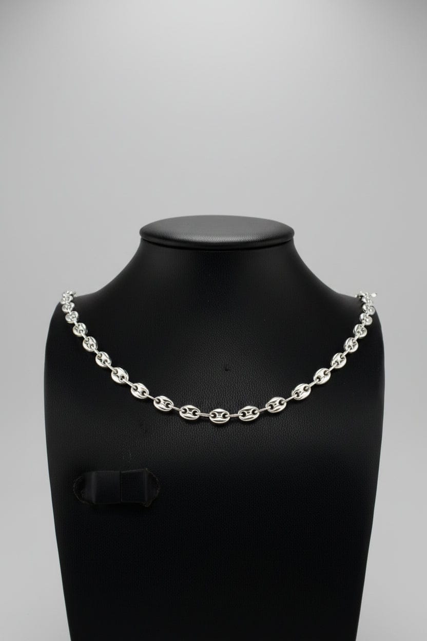 Silver chain necklace on a black mannequin against a blurred background