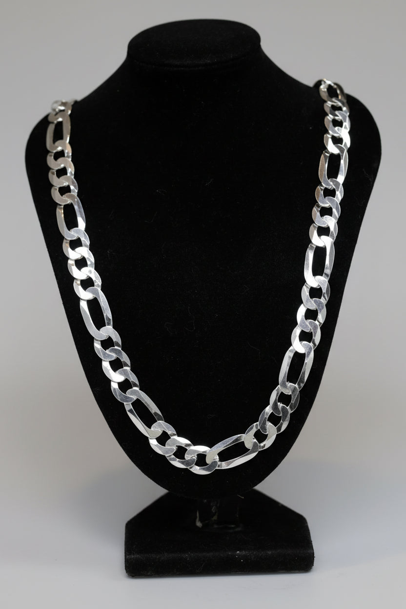 Silver chain necklace on a black mannequin bust against a dark background