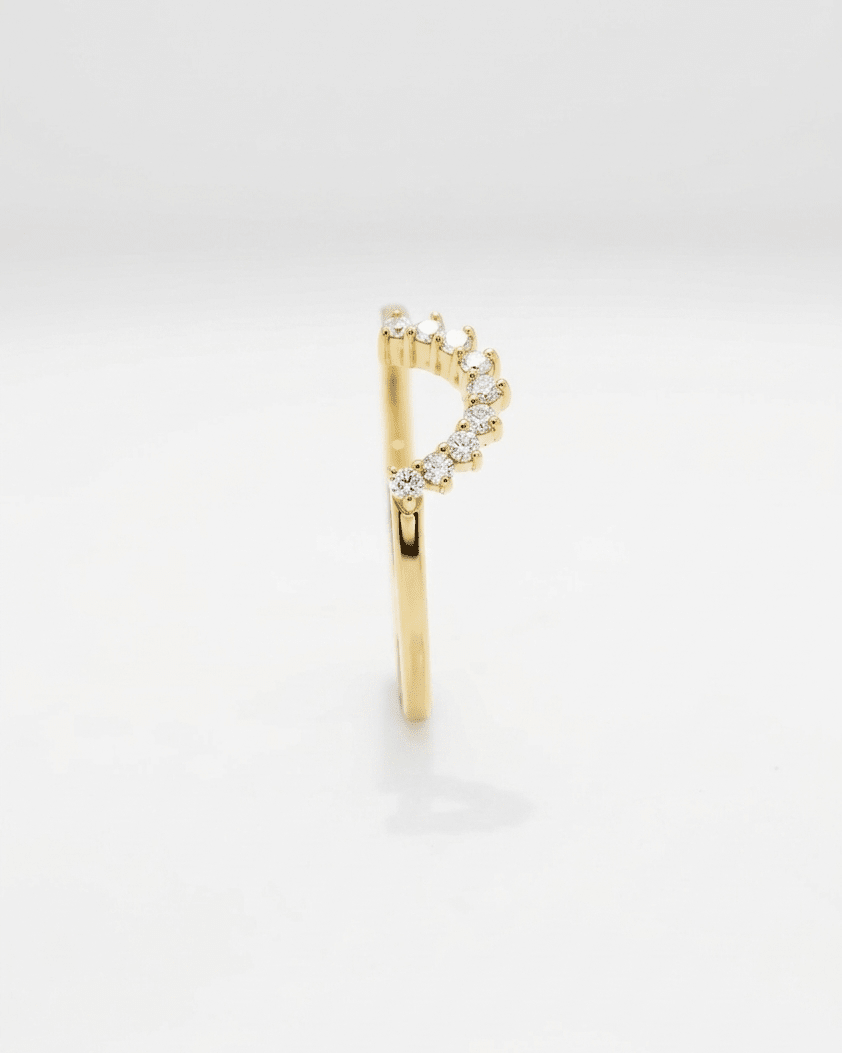 Gold earring with small diamonds on a light gray background