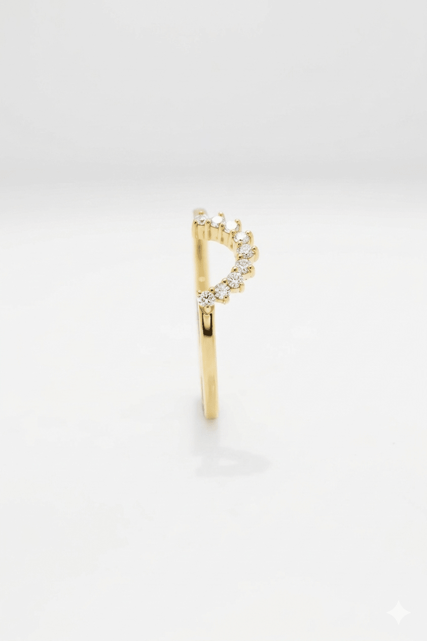 Gold earring with small diamonds on a light gray background