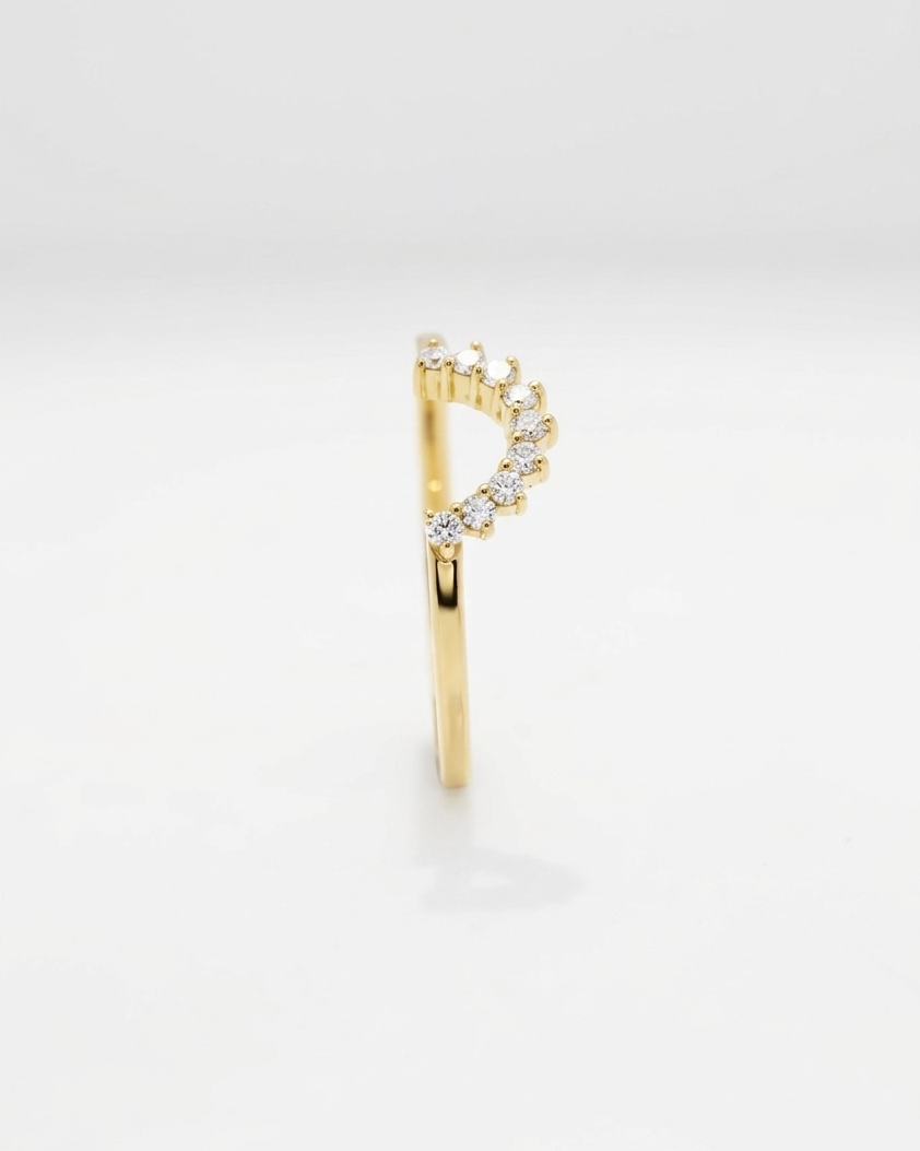 Gold earring with small diamonds on a light gray background