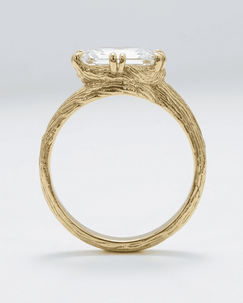 Gold ring with a large diamond on a light gray background