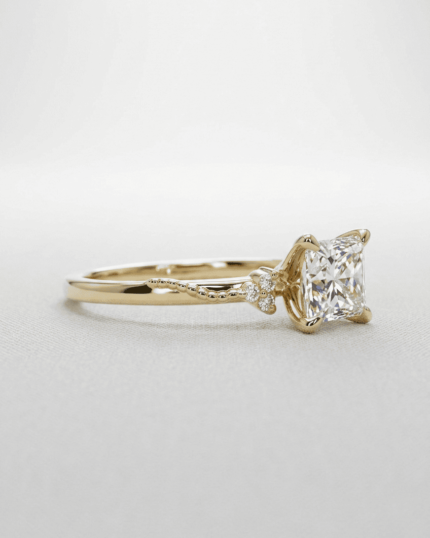 Gold ring with a diamond on a light gray background