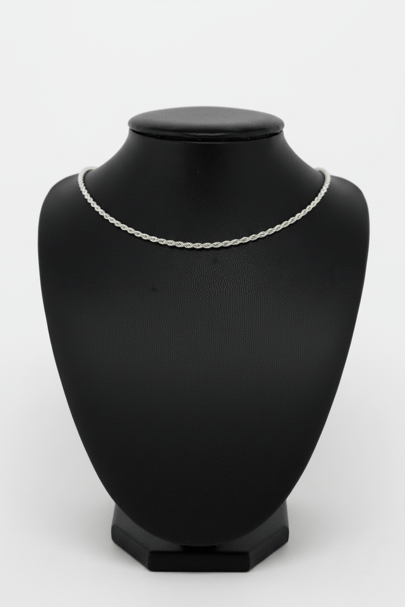 Silver necklace on a black mannequin bust against a white background