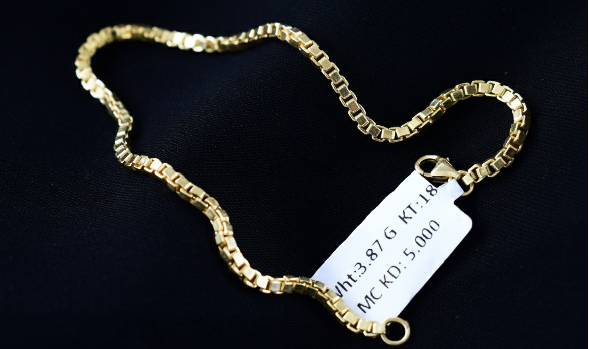 Gold chain with a tag on a black background