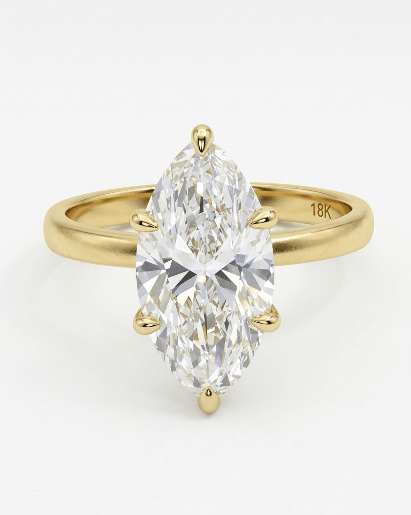 Gold ring with a pear-shaped diamond on a white background