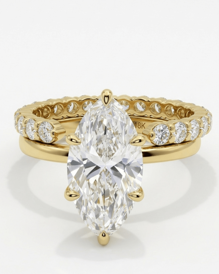 Gold ring with a pear-shaped diamond on a white background