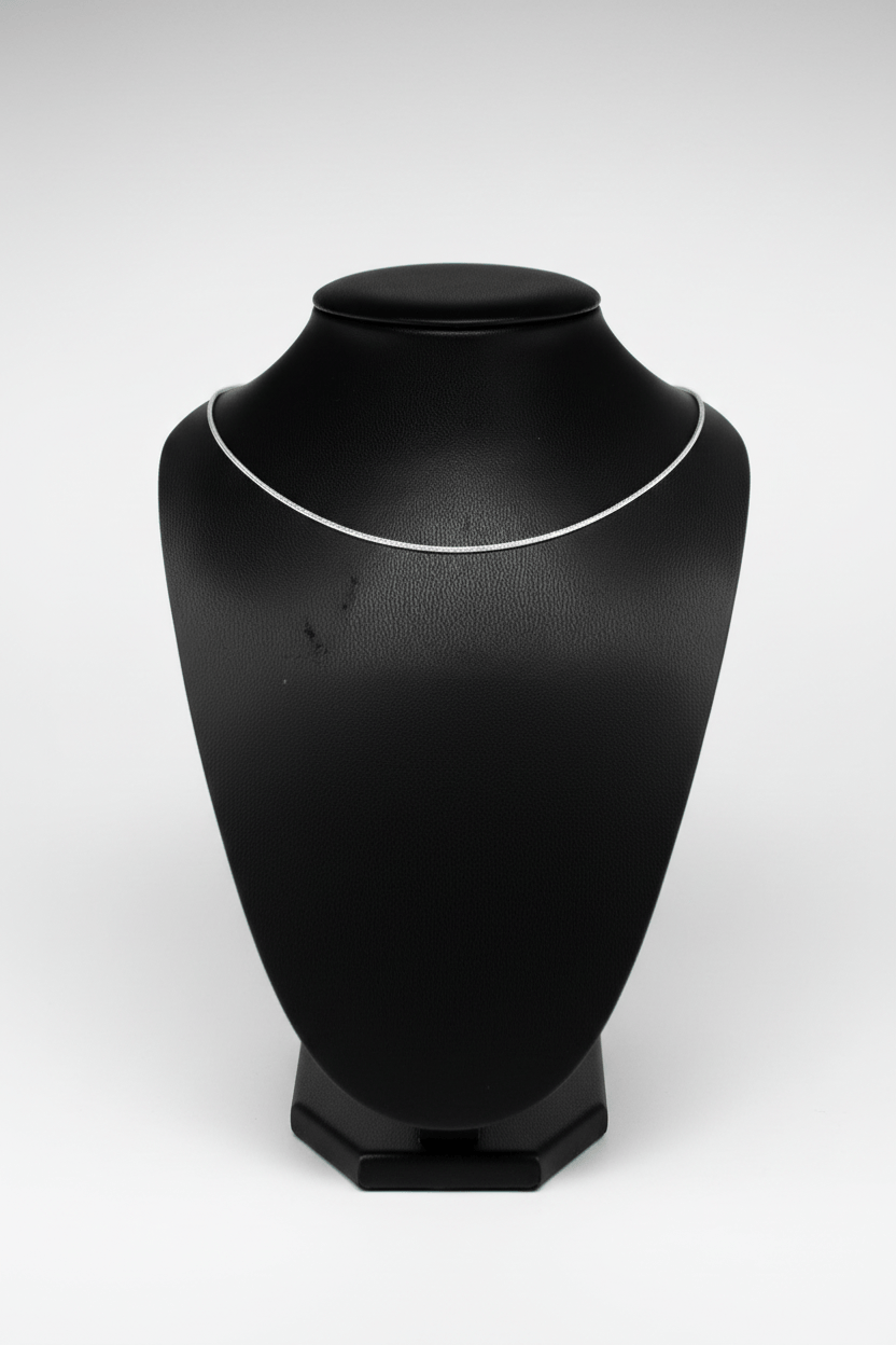 Silver necklace on a black mannequin bust