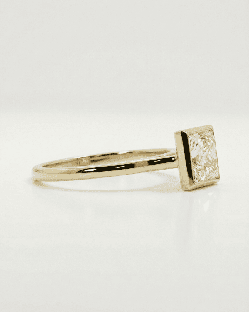 Gold ring with a square-cut diamond on a white background