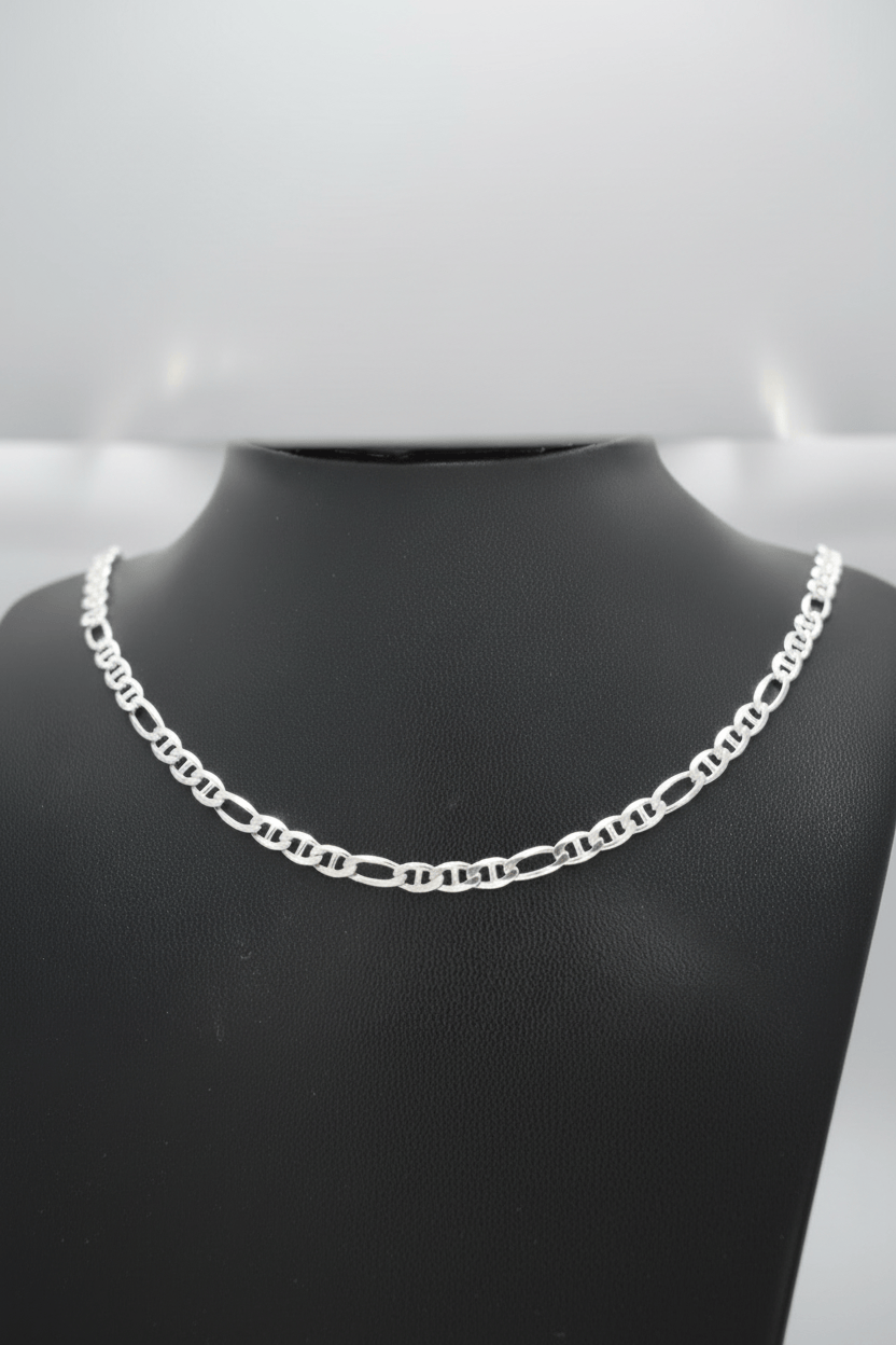 Silver chain necklace on a black mannequin bust against a gray background