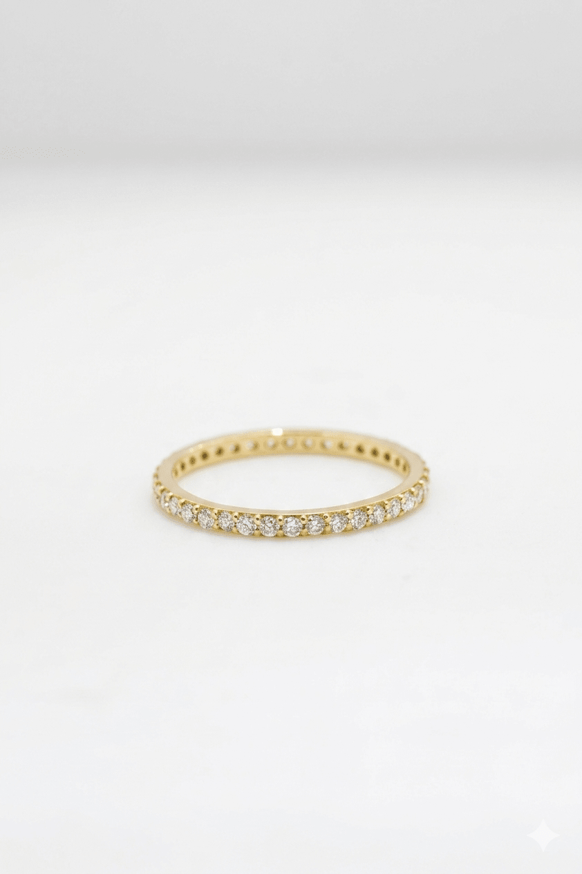 Gold ring with small diamonds on a light gray background