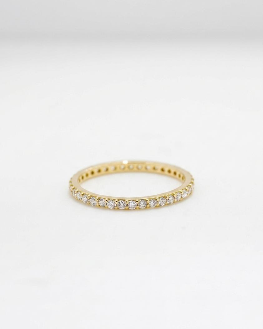 Gold ring with small diamonds on a light gray background