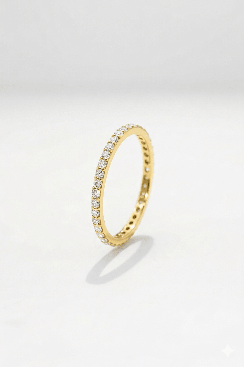 Gold ring with embedded diamonds on a light gray background