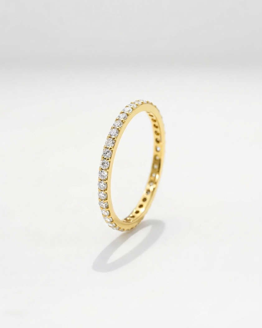Gold ring with embedded diamonds on a light gray background