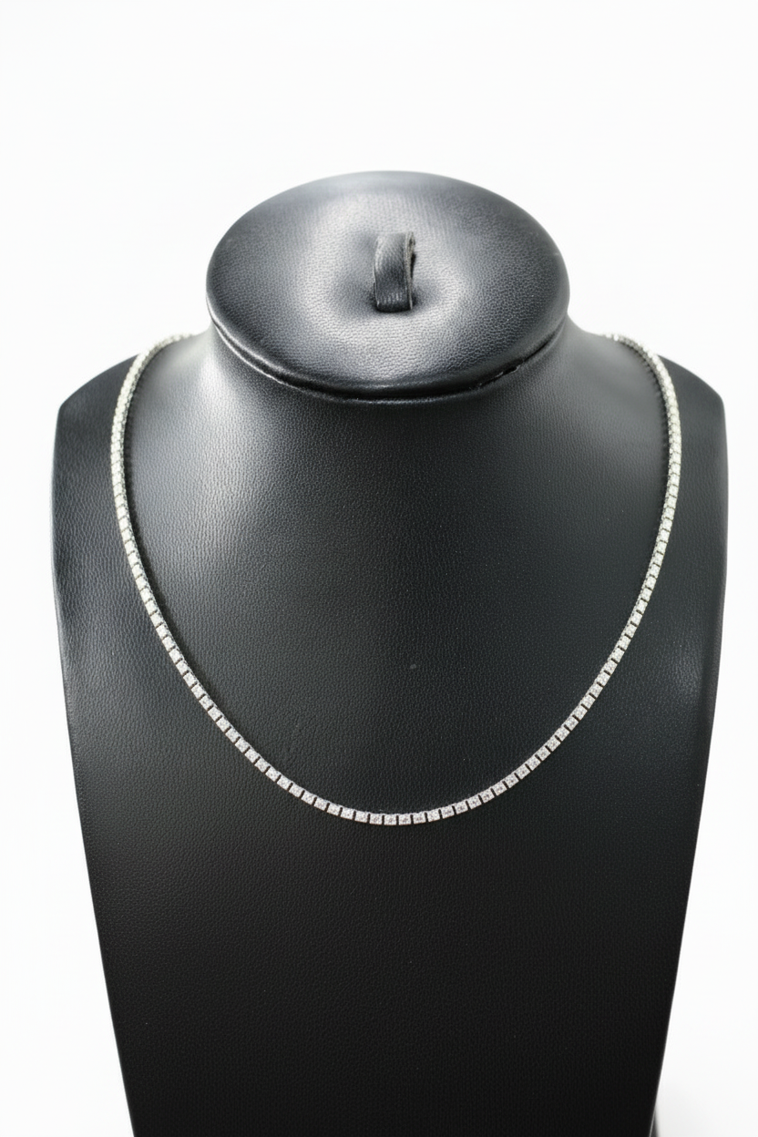 Silver necklace on a black mannequin bust with a white background