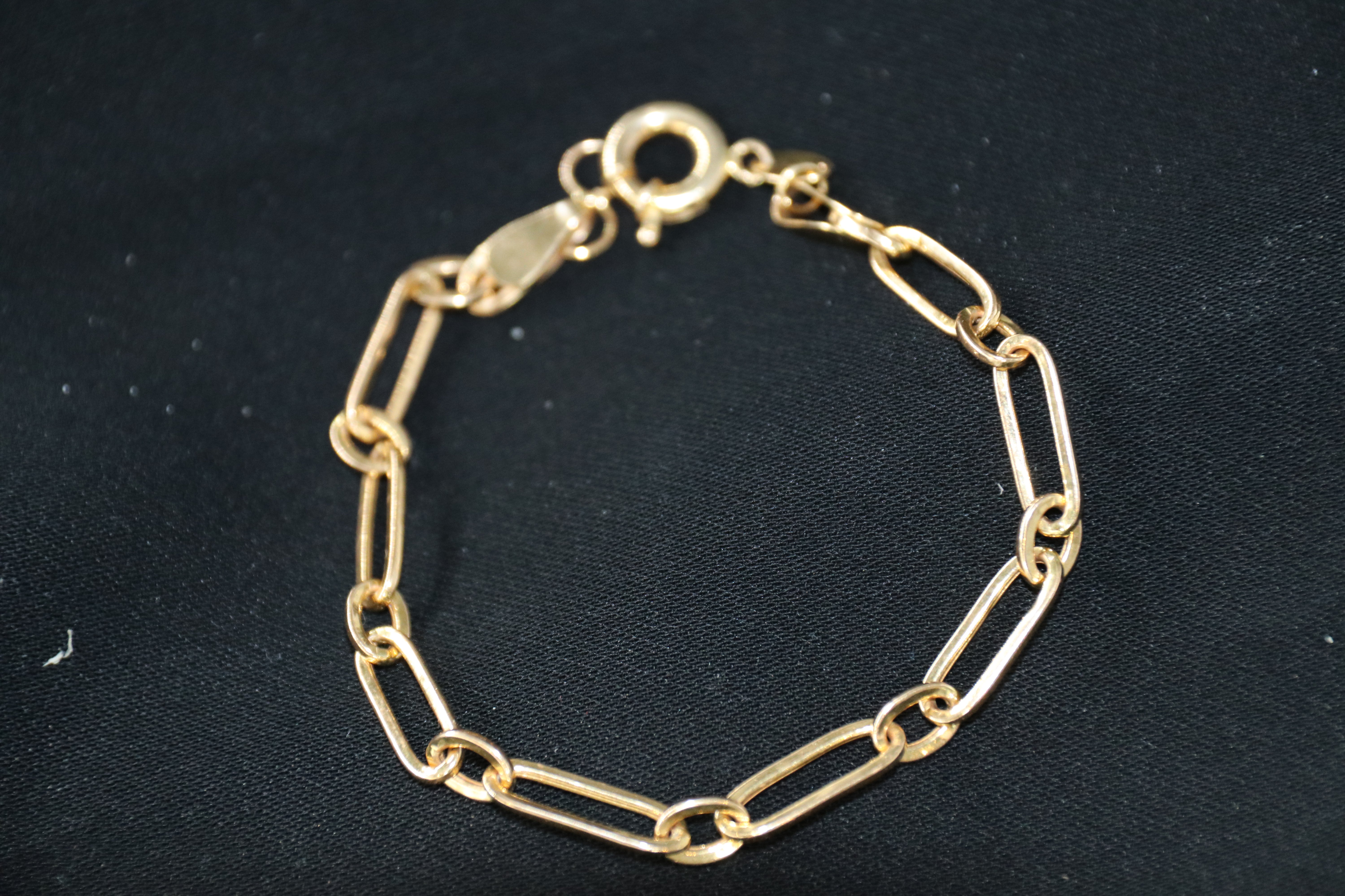Gold chain bracelet on a black background