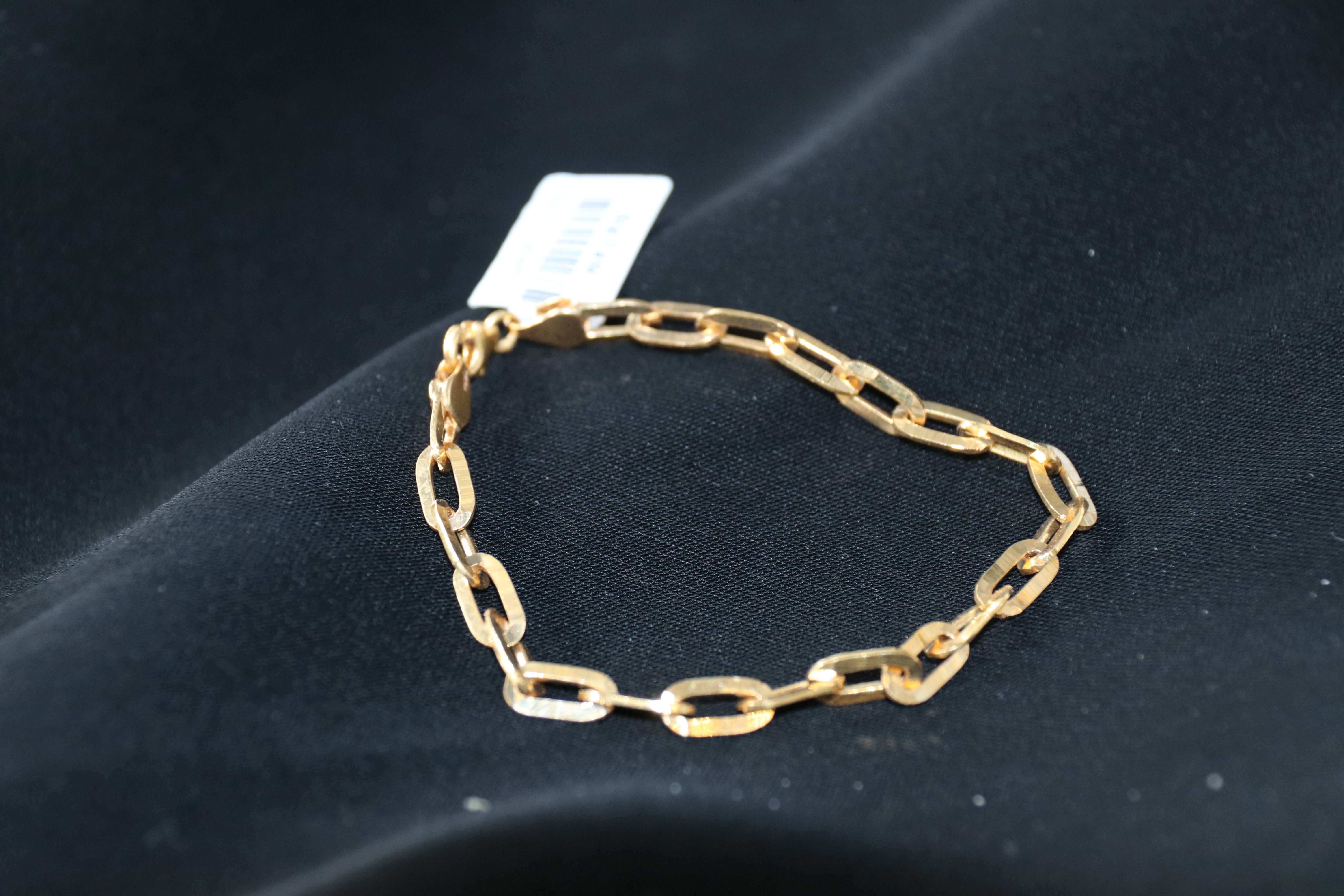 Gold chain bracelet on a dark surface