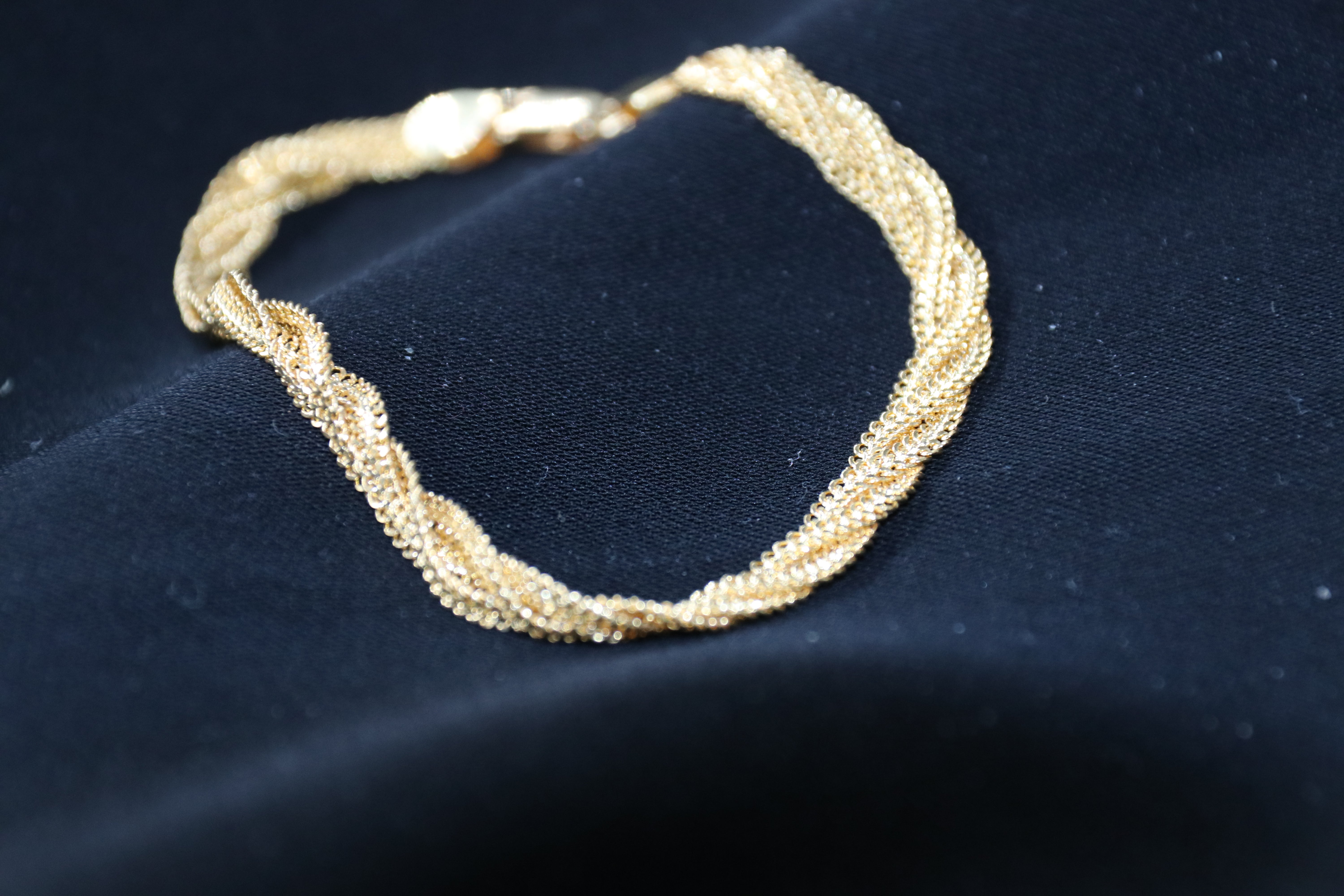 Gold bracelet on a dark blue fabric background