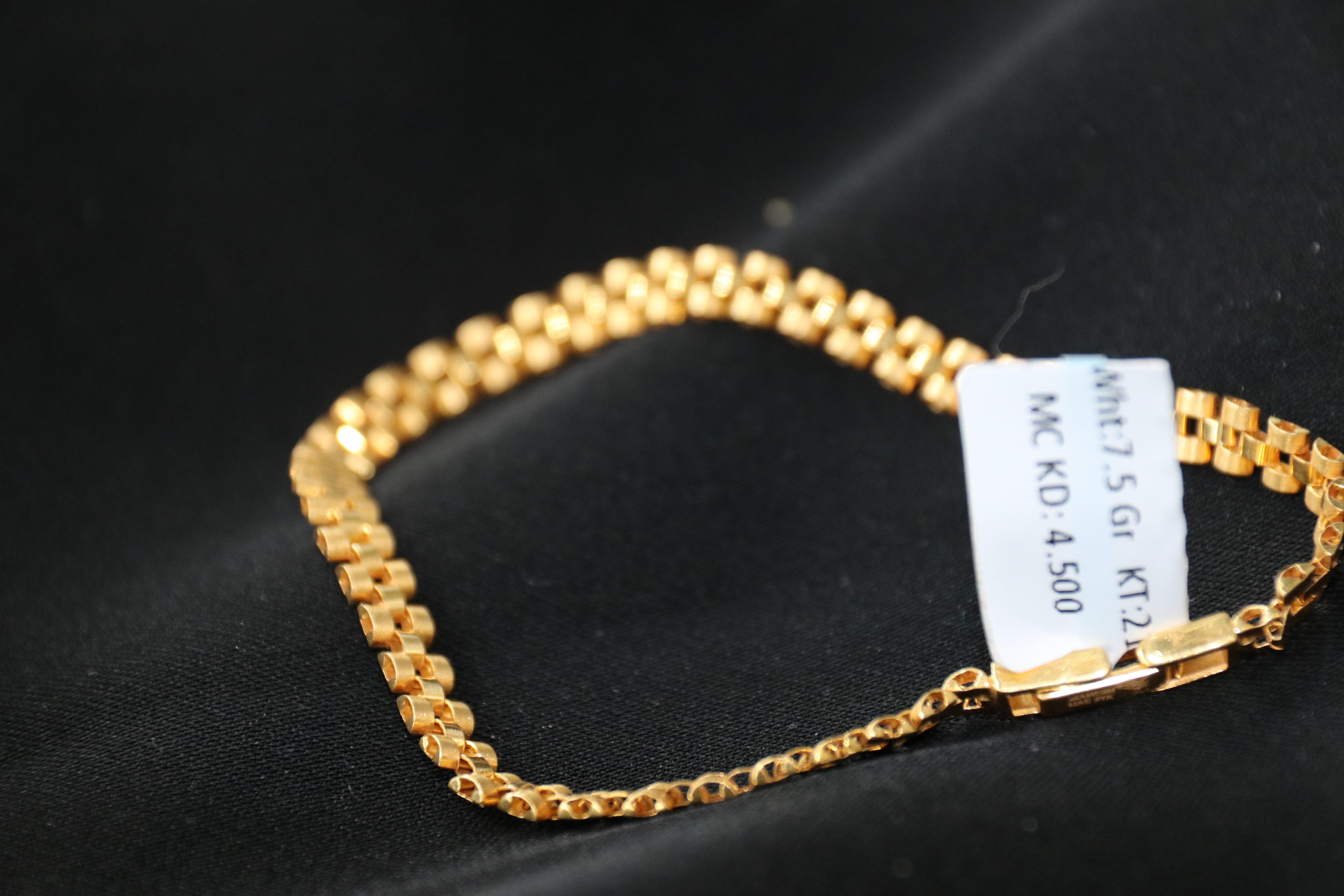 Gold bracelet with a label on a black background