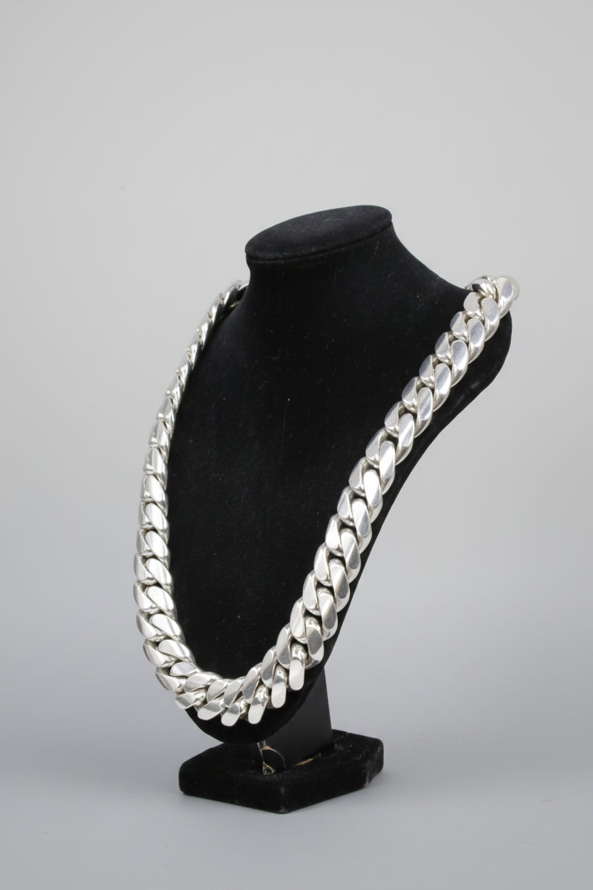 Black velvet jewelry display with silver chain design on a white background