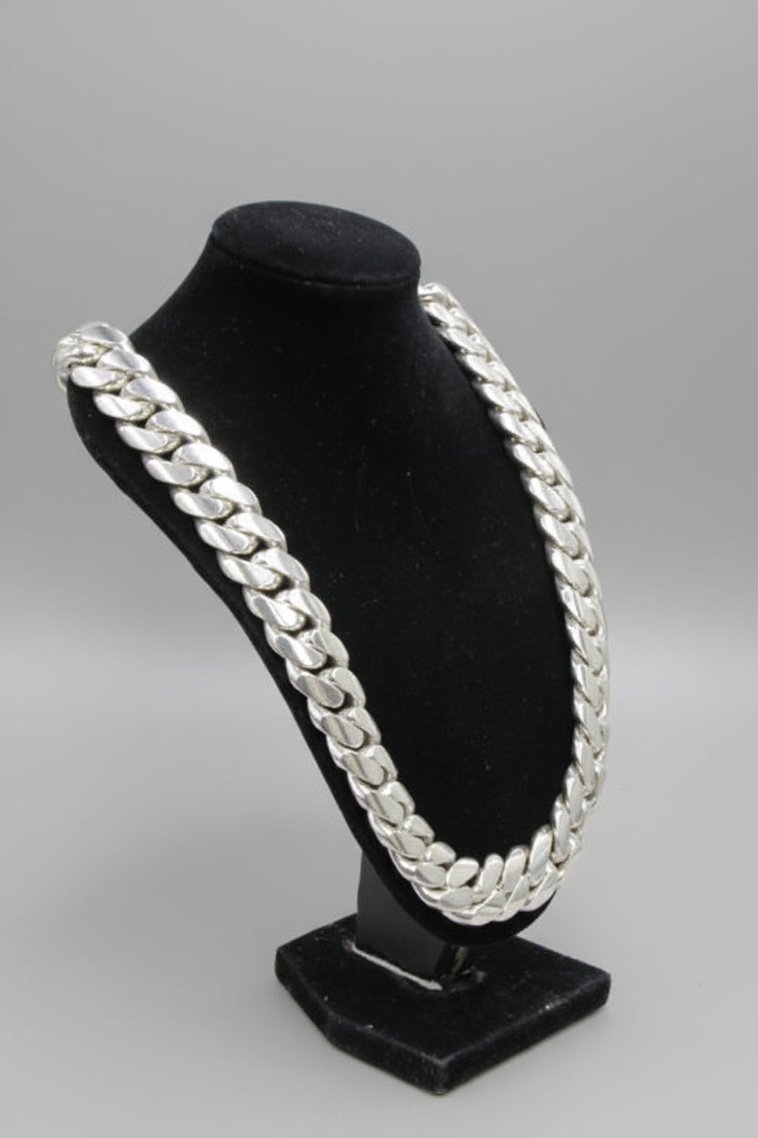 Black jewelry stand with silver chain design on a white surface