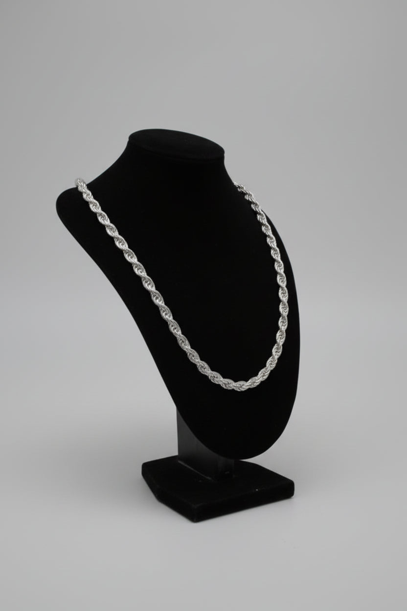 Black hat with a silver chain on a mannequin head against a blurred indoor background
