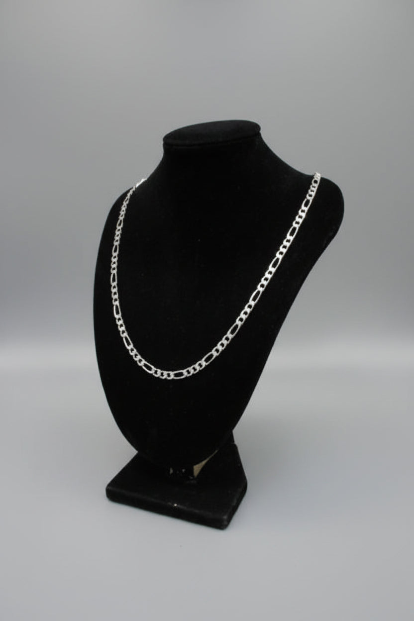 Black velvet jewelry box with a silver chain on a textured surface