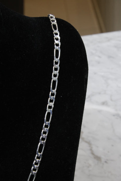 Silver chain belt on a black garment with a white background