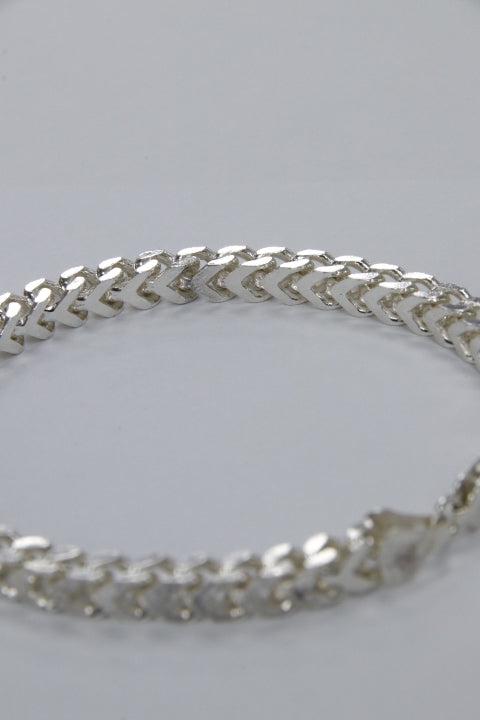 Silver chain bracelet on a light gray background