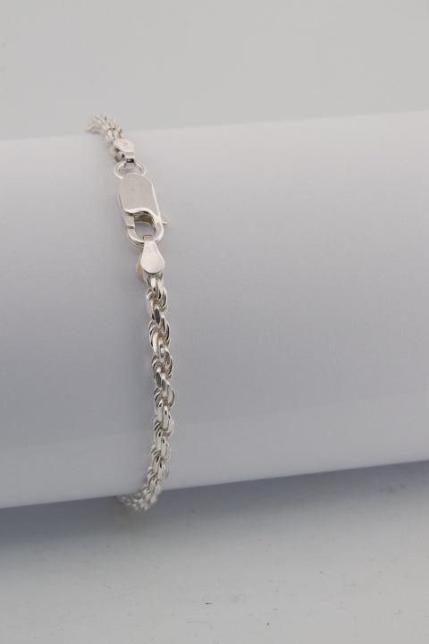 Silver bracelet on a gray cylindrical stand
