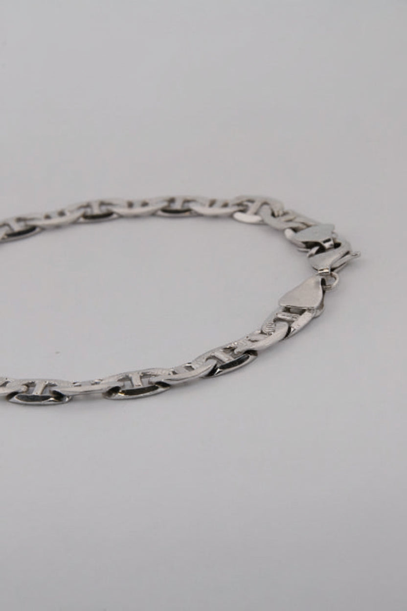 Silver chain necklace on a light gray background