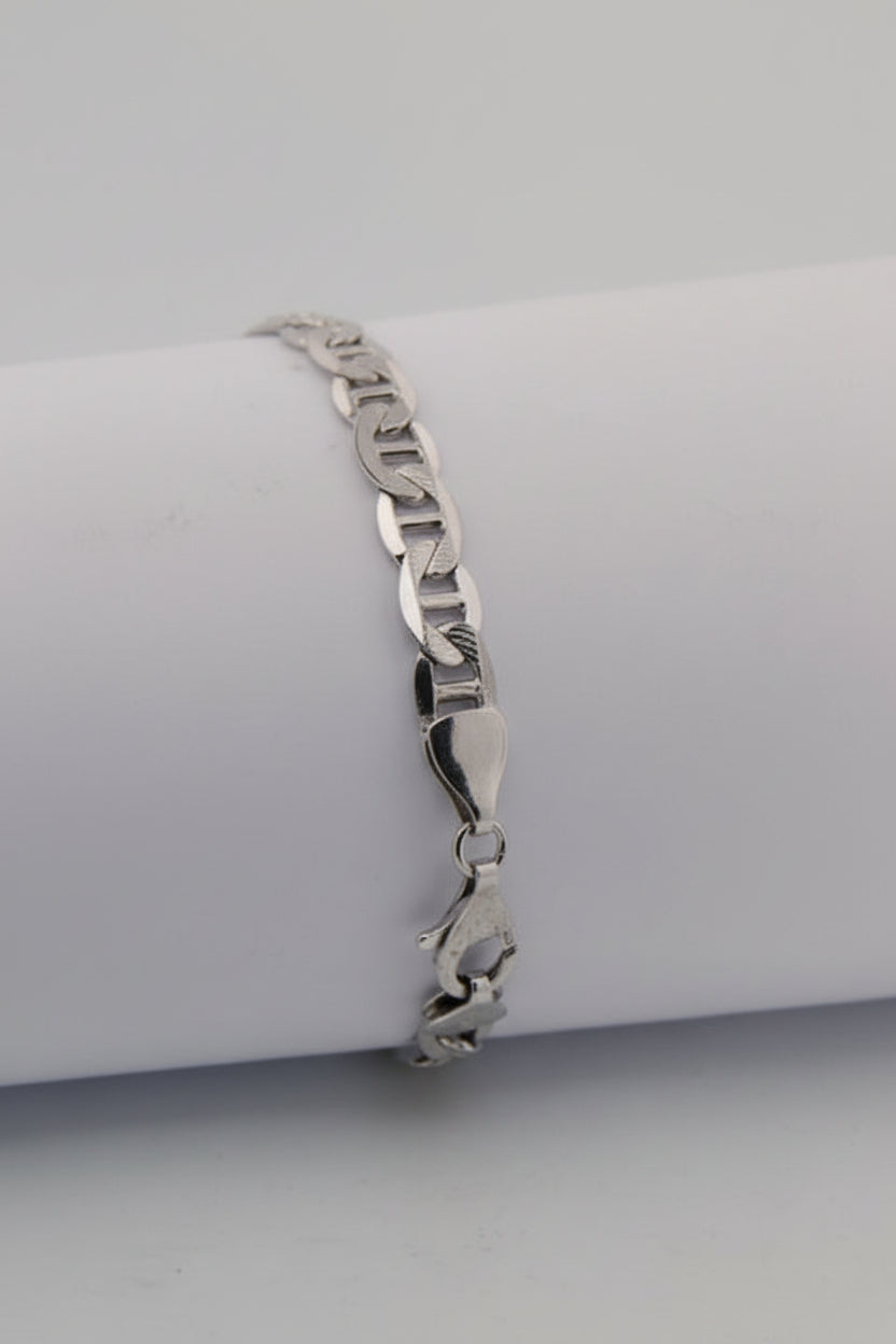 Silver bracelet on a white cylindrical stand