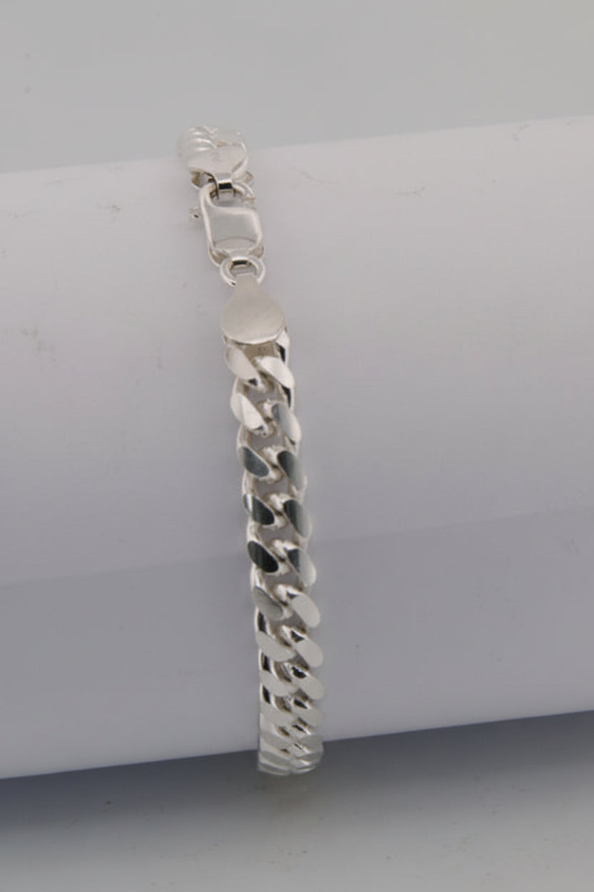 Silver chain bracelet on a white cylindrical object