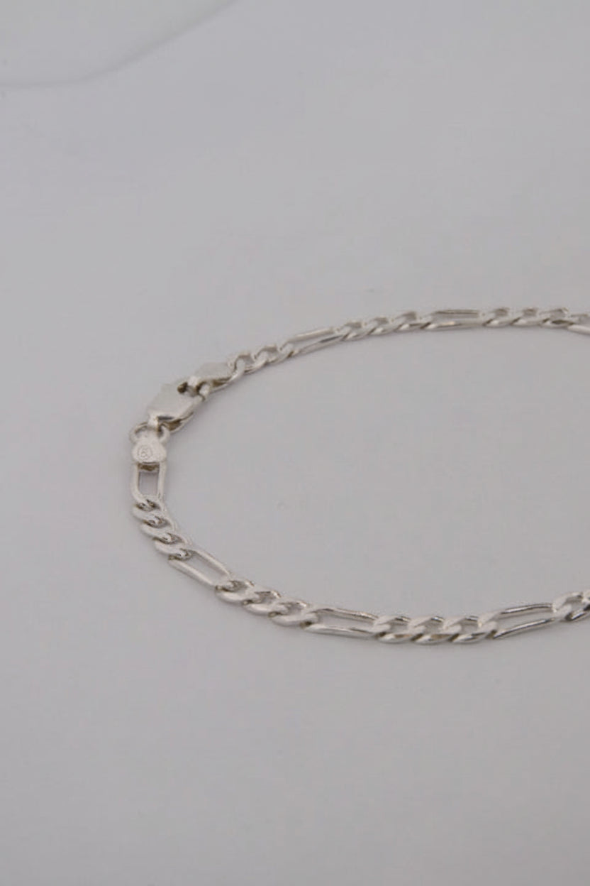 Silver chain bracelet on a light gray background