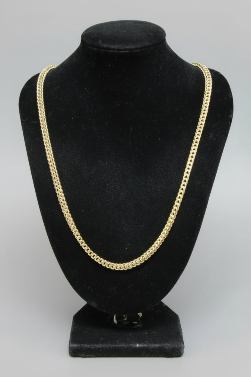 Black hat with gold trim on a white surface