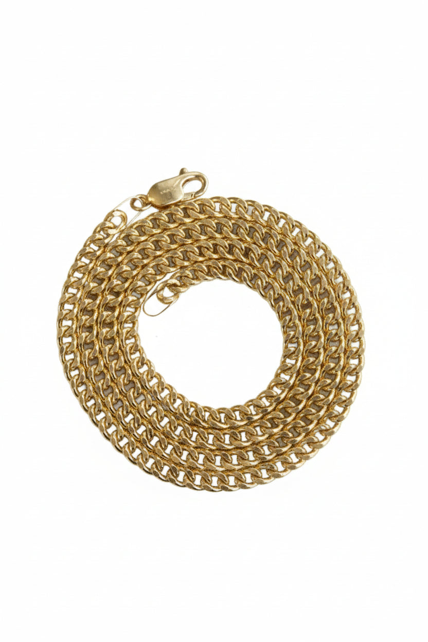 Gold chain necklace on a white surface