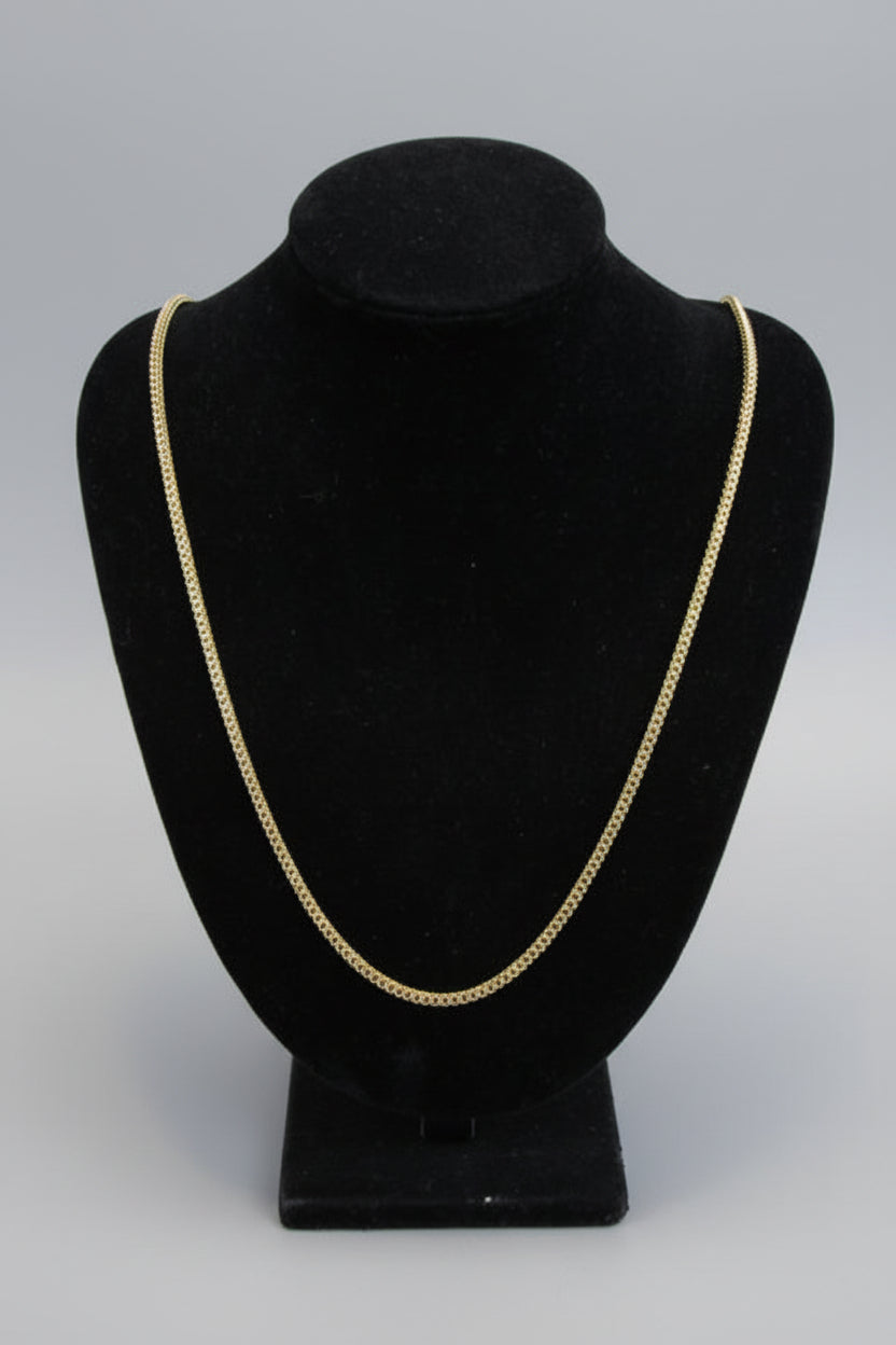 Black hat with gold trim on a mannequin head against a neutral background