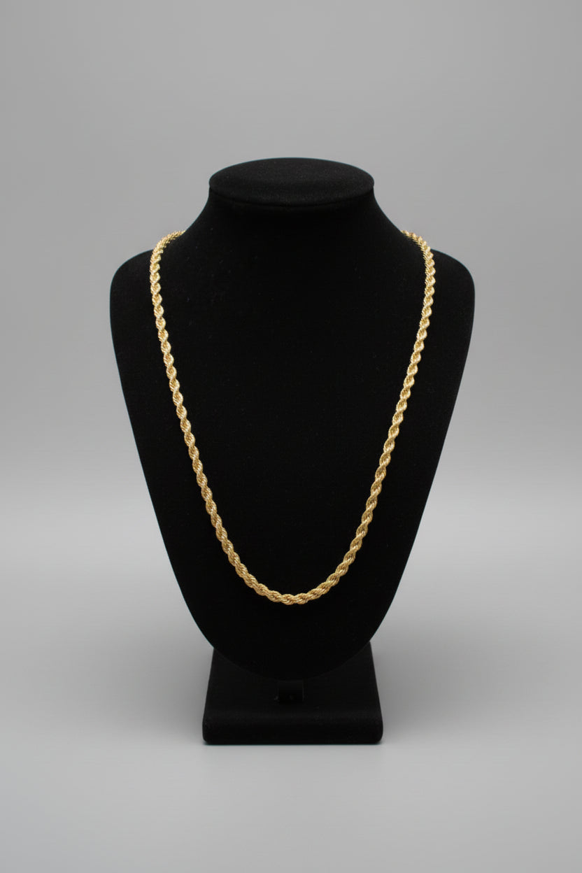 Black velvet hat with gold chain on a marble surface