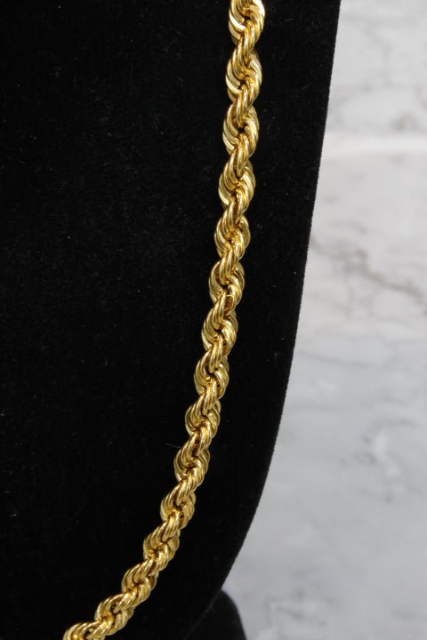 Gold rope chain on a black background