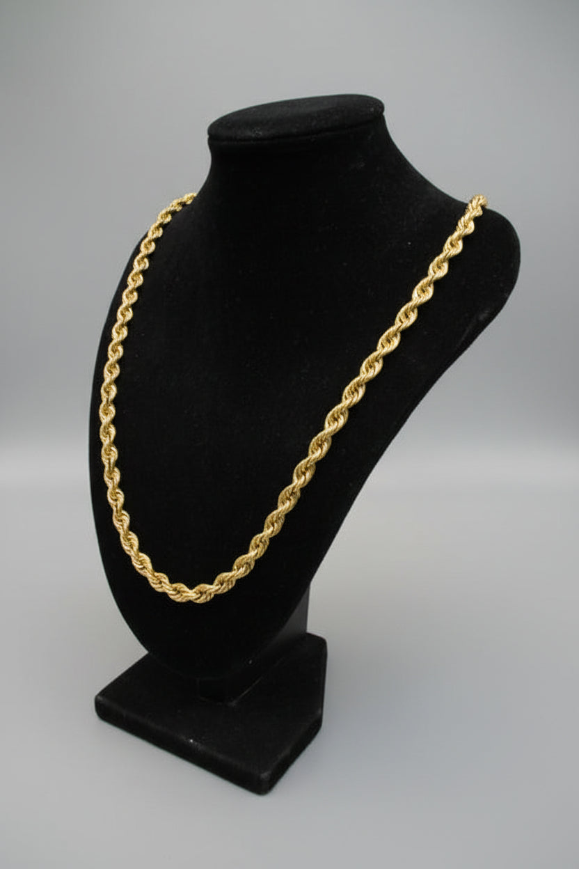 Black headband with gold chain on a marble surface