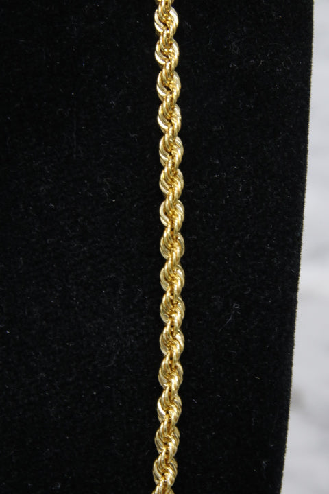 Gold rope chain on a black fabric background