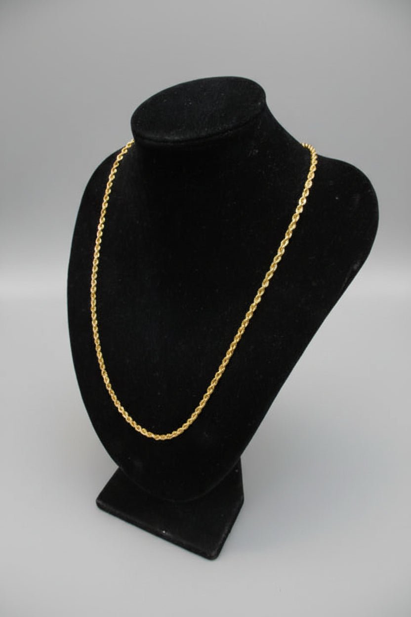 Black hat with gold trim on a marble surface