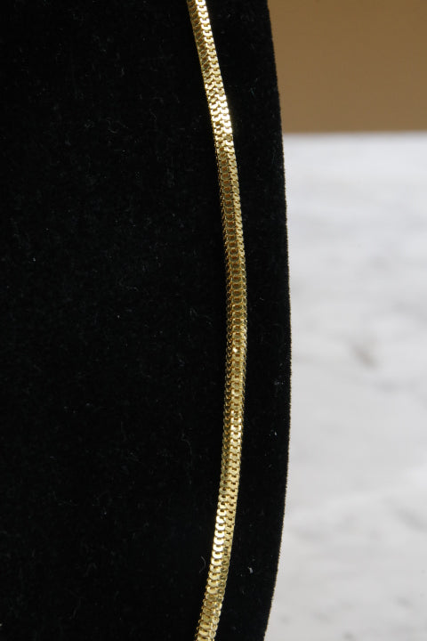 Close-up of a black hat with a gold band on a white background