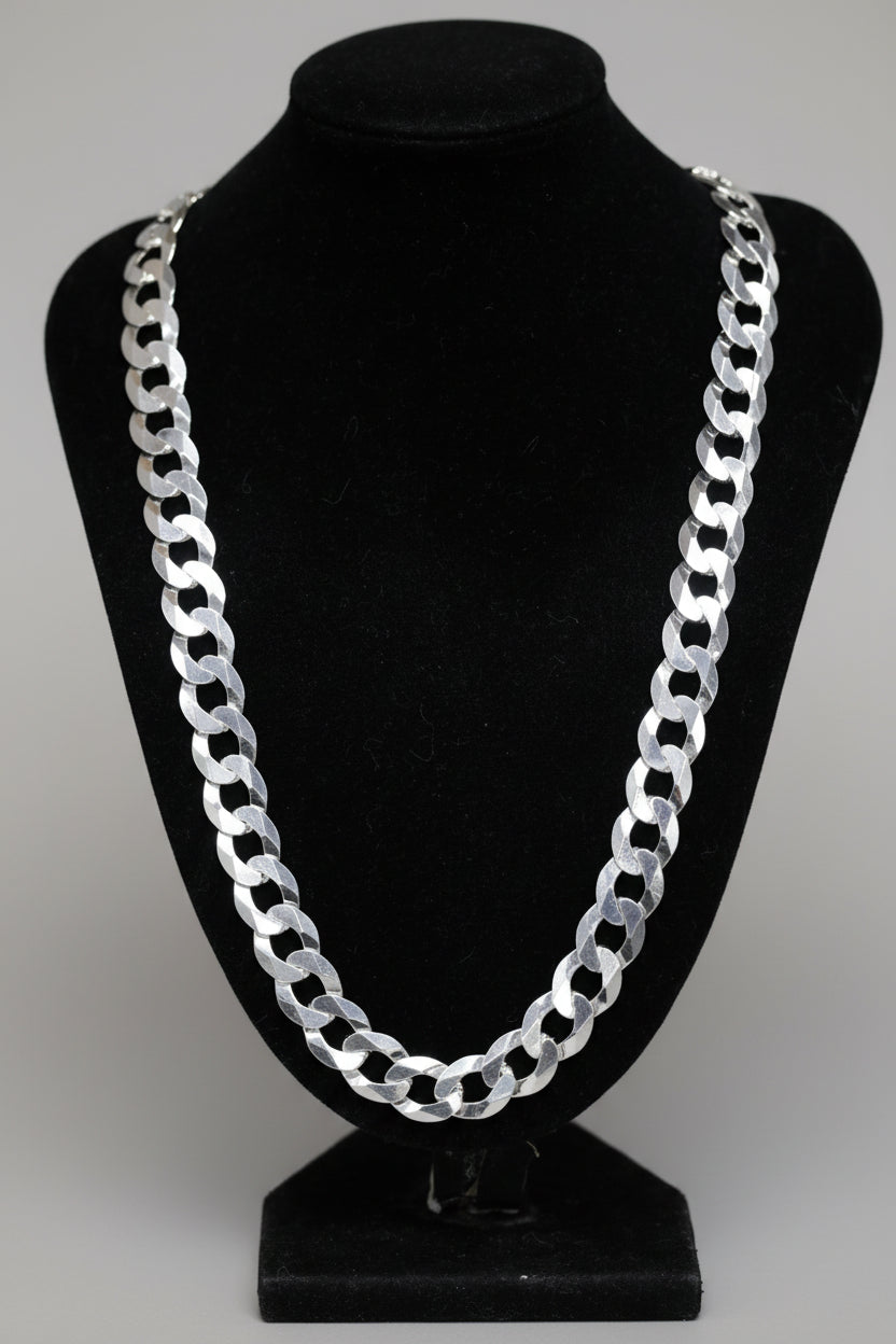 Silver chain necklace on a black mannequin bust with a blurred background