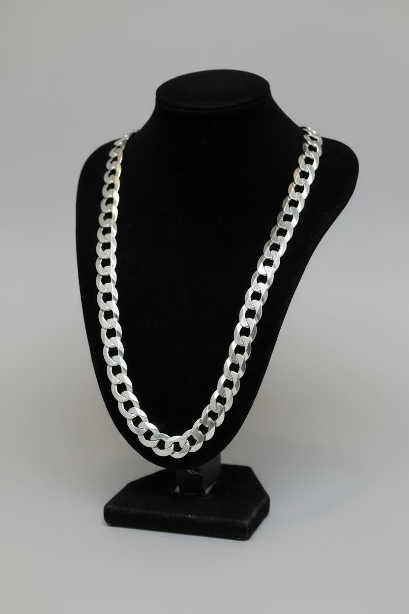 Silver chain necklace on a black stand with a blurred background